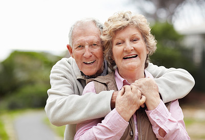 Happy senior man embracing mature woman in countryside