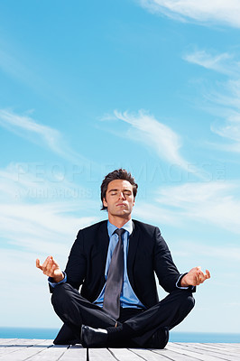 Relaxed business man meditating with copyspace on a pier
