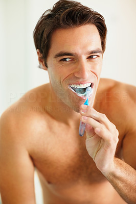 Handsome young shirtless man brushing his teeth