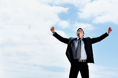Happy business man with arms wide open against sky