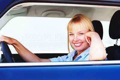 Pretty woman smiling from the driver\'s seat of a car