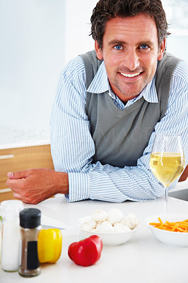 Happy mature man standing in the kitchen