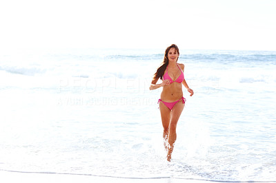 Attractive young girl running in water at the sea