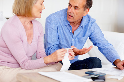 Worried senior couple discussing their expenses at home