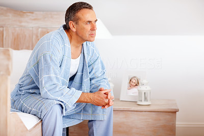 Thoughtful mature man in bathrobe looking away