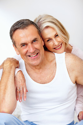 Woman embracing mature man from back against colored background