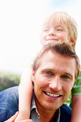 Smiling mature man giving his son piggyback ride