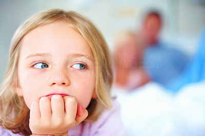 Young girl with hand on chin while blur people in background