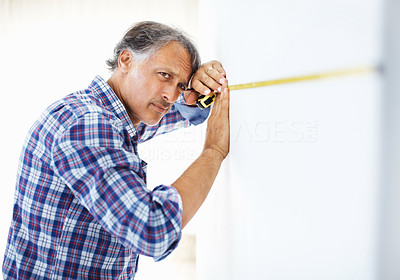 Architect measuring wall with masking tape