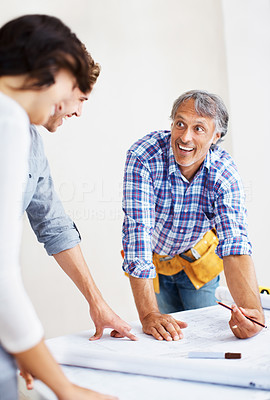 Mature engineer discussing plans with young couple