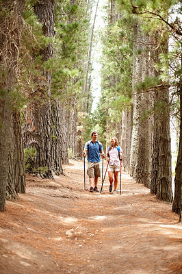 Couple walking in the woods with hiking poles