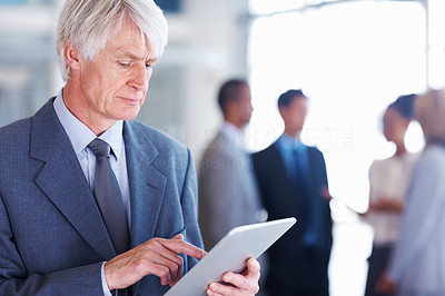 Senior male executive using electronic tablet