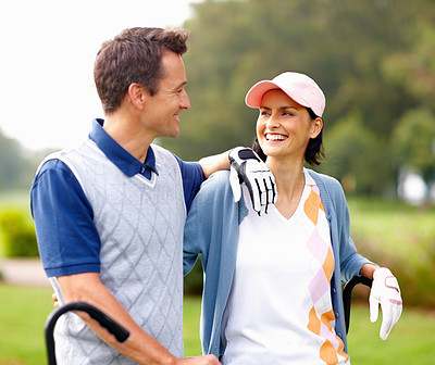 Couple smiling and looking at each other on golf course