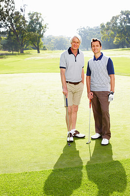 Father and son standing on golf course