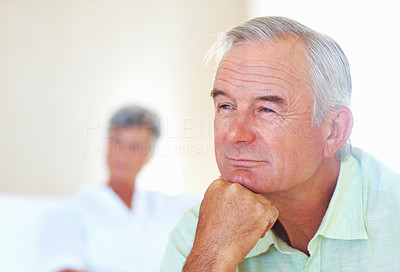 Mature man thinking with woman in background