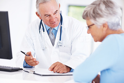 Doctor discussing medical report with mature patient