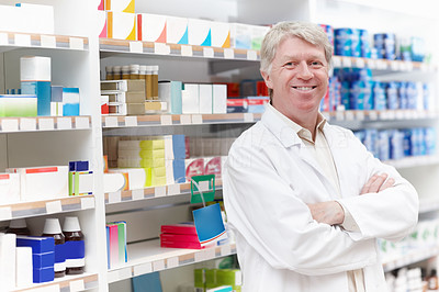 Smiling pharmacist near shelf at medical store