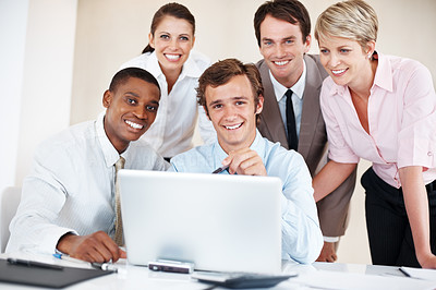 Group of business people smiling together with a laptop