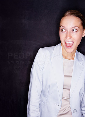 Excited mouth opened business woman against black background