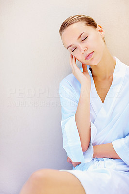 Female in a bathrobe fallen asleep against a wall