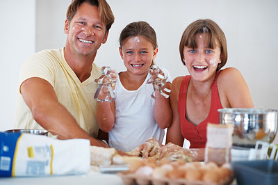 Smiling family preparing cookies in kitchen