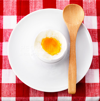 Lightly boiled egg in eggcup with wooden spoon