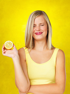 Pretty woman holding a sour lemon