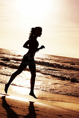 Young female running during sunset on beach