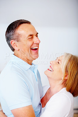 Romantic senior couple hugging against blank background