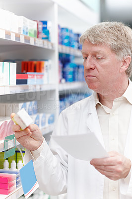 Pharmacist checking medicine with prescription