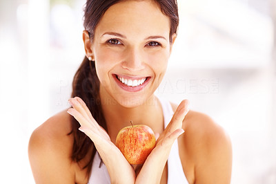 Pretty young female smiling with an apple in hand
