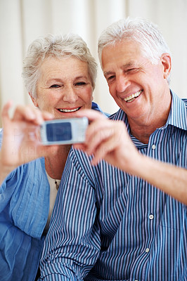 Happy senior couple taking a self portrait on mobile phone