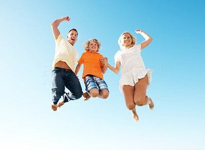Happy family jumping in air against sky