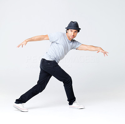 Young male hip hop dancer posing on grey background