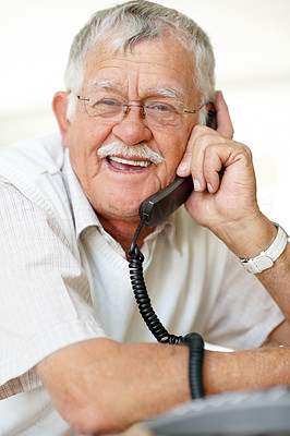 Smiling senior man talking on telephone