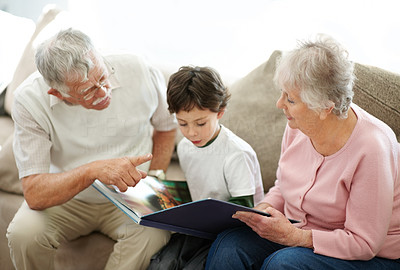 Young boy and his grandparents reading a story together