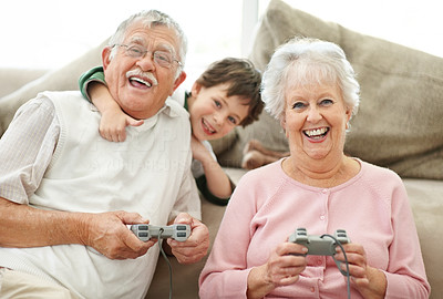 Grandparents and little boy having fun playing video games