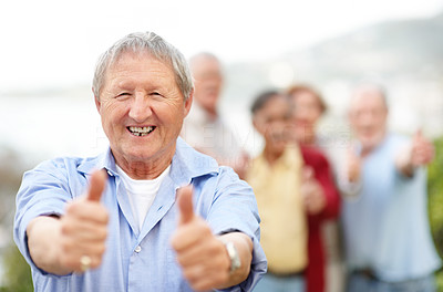 Smiling senior man giving you thumbs up with both hands - Outdoor