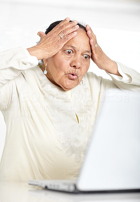 Surprised - Senior female using laptop with hand on head