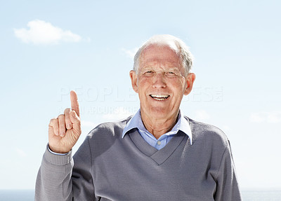 Smiling senior man pointing upwards - Outdoor