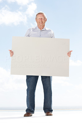 Happy senior guy holding a blank billboard