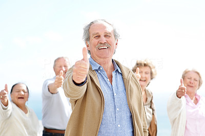 Confident old man showing thumbs up sign with his friends