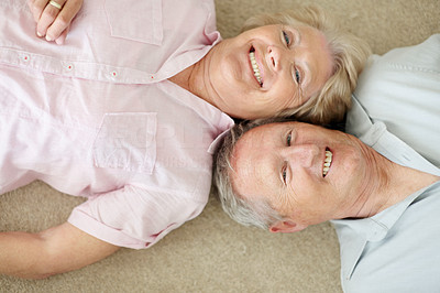 Mature couple lying down with their heads together