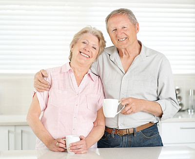 Romantic old couple having coffee in the kitchen