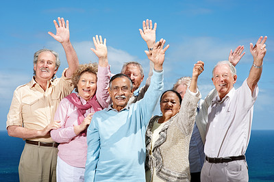 Group of mature friends standing with raised hands