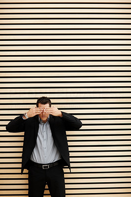 Business man covering eyes with his hands