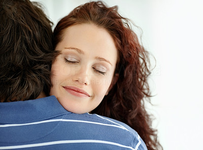 Cute female hugging a man with eyes closed