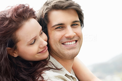 Closeup of a cute female hugging guy from behind
