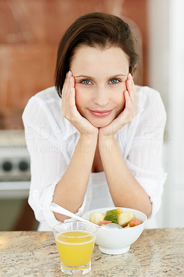 Pretty young woman with hands on face at breakfast table
