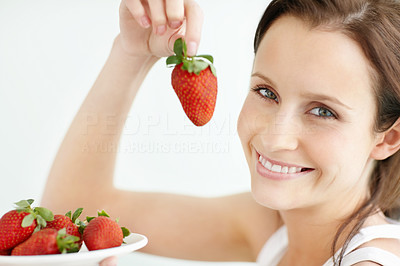 Closeup of a smiling female holding a plate of strawberries